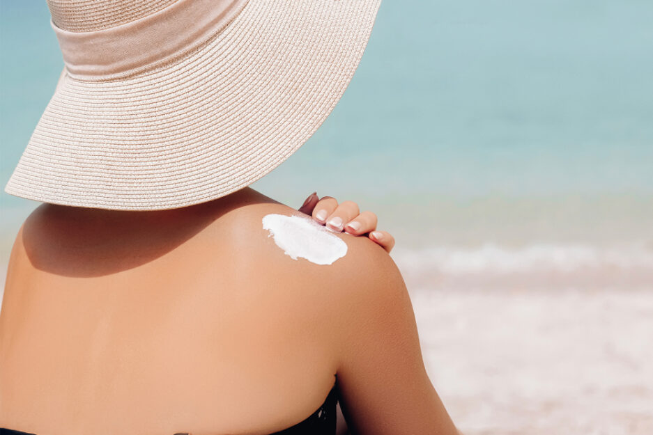 woman applying sunscreen spf on beach