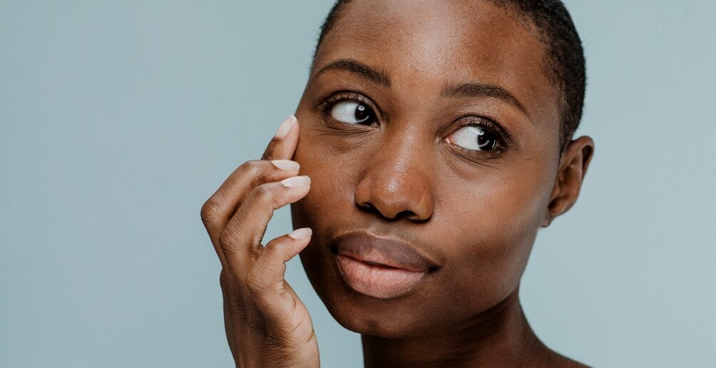 woman touching her face on a blue background