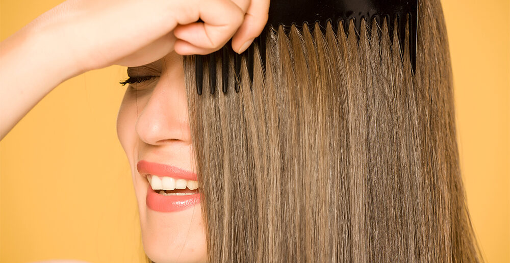 happy woman combing hair